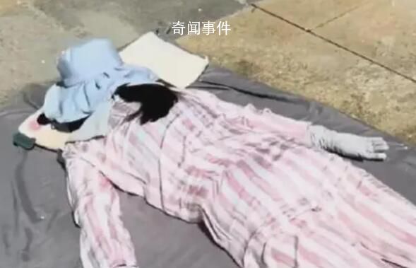 女子高溫全副武裝趴水泥地上曬背 吸引了大眾的眼光