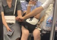 情侶地鐵上隔人坐仍手拉手 這究竟是怎么回事